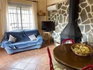 a living room with a blue couch and a fireplace at Corralets in Confrides