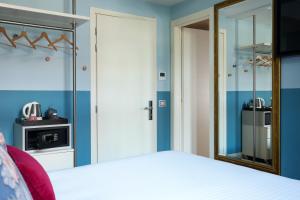 a bedroom with a bed and a mirror at Hotel Indigo Verona - Grand Hotel Des Arts by IHG in Verona +107 photos