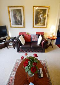a living room with a couch and a table with roses at Inverlochy Villas (Adults Only) in Fort William