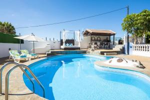 una piscina con uno scivolo davanti a una casa di Villa Colmena by Villa Plus a Guía de Isora