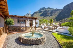 una fontana nel cortile di una casa con le montagne sullo sfondo di Villa Colmena by Villa Plus a Guía de Isora