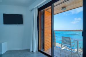 a room with a sliding glass door with a view of the ocean at Hotel Boutique La Marquesina - Adults Only in Corralejo