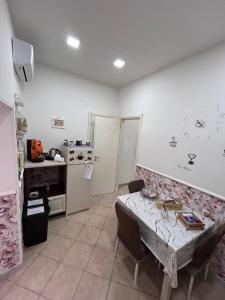 una cucina con un tavolo e una cucina con un fornello di Casa vacanza Vinci house Ercolano a Ercolano