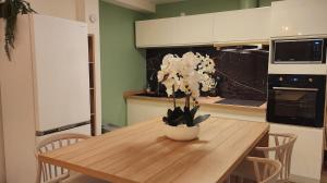 a kitchen with a wooden table with a vase of flowers on it at Ti Kaz Angelyn - T2 Cozy avec Spa! in Saint-André