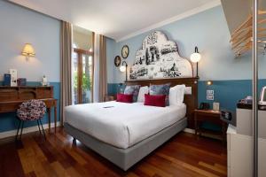 a bedroom with a large white bed with red pillows at Hotel Indigo Verona - Grand Hotel Des Arts by IHG in Verona