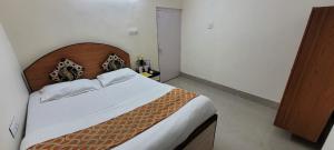にあるLily and Lotus 2 Cozy 1Bhk Compact Full Furnished AC Apartment Managed by Hotel Airwaysの木製のヘッドボードが付いた大きなベッドのある寝室
