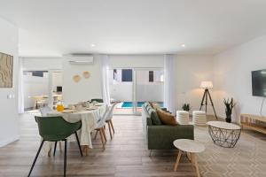 sala de estar con mesa y sillas y sala de estar. en Modern Villa with Private Pool Near Baleal Beach, en Atouguia da Baleia