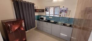 にあるLily and Lotus 2 Cozy 1Bhk Compact Full Furnished AC Apartment Managed by Hotel Airwaysのシンクとカウンタートップのあるキッチン +4枚の写真
