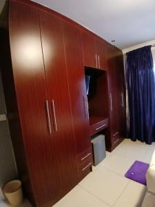 a large wooden cabinet in a bedroom at Kimberland Guest House Block 10 in Gaborone
