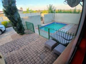 a swimming pool in a backyard with a fence at Kimberland Guest House Block 10 in Gaborone