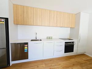 クイーンズタウンにあるAmazing remarkable view, 7 min from airportの白いキャビネットと黒の電化製品が備わるキッチン +25枚の写真