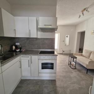 a kitchen with white cabinets and a stove at Vila Natasa Apartment 2 near Plitvice in Vrhovine