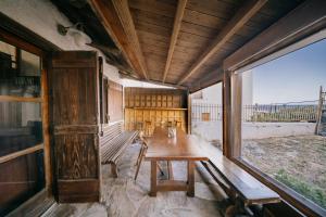 an empty room with a wooden table and benches at Seaside Wooden Cottage Retreat in Karfas +2 photos