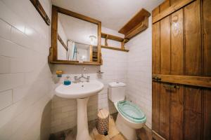 a bathroom with a sink and a toilet and a mirror at Seaside Wooden Cottage Retreat in Karfas