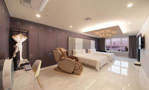 a bedroom with a bed and a chair in it at Restia Incheon Bay Hotel in Incheon