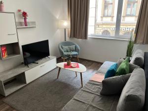 een woonkamer met een bank en een tv bij Nova City Apartments in Boedapest