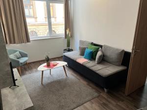 een woonkamer met een bank en een tafel bij Nova City Apartments in Boedapest