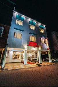 a blue building with a red sign on it at HOTEL Le GRAND in Jāmb