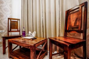 two wooden tables and chairs in a room with curtains at HOTEL Le GRAND in Jāmb