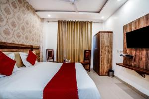 a bedroom with a large bed and a flat screen tv at HOTEL Le GRAND in Jāmb