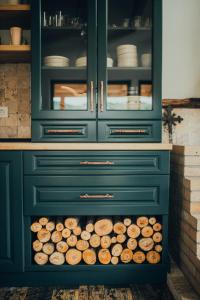a kitchen with green cabinets with wooden logs in it at Adăpost Transalpina in Căpîlna +12 photos