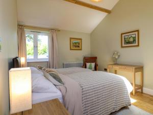 a bedroom with a bed and a window at Petal Cottage in Laxton