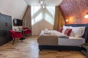 ein Schlafzimmer mit einem Bett und einem Tisch in einem Zimmer in der Unterkunft Villa Clariss in Balatonalmádi