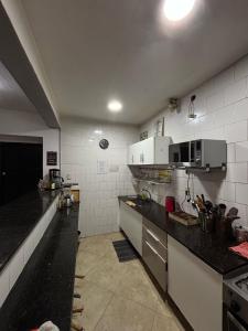 モンテビデオにあるMontevideo Chic Hostelのキッチン(黒いカウンタートップ、白い電化製品付)