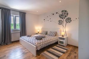 a bedroom with a bed and a tree on the wall at Villa Zupan by Villa Plus in Vranići +20 photos