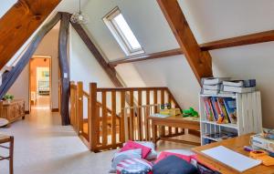 a room with a staircase and a table with books at La Charmille in Saint-Étienne-lʼAllier