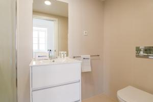 a bathroom with a white sink and a toilet at Bright Flat in Historic Foz House by HostWise in Porto