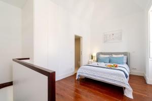 a bedroom with a bed with blue pillows at Bright Flat in Historic Foz House by HostWise in Porto