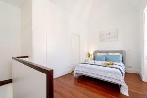 a bedroom with a bed with blue pillows at Bright Flat in Historic Foz House by HostWise in Porto