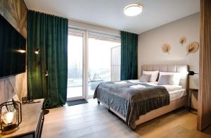 a bedroom with a bed and a large window at Comfortable apartment, sauna Żywiec Lake in Zarzecze