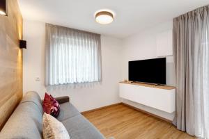 a living room with a couch and a flat screen tv at Appartement Sonnlicht Pfalzen in Falzes