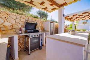 een keuken met een fornuis en een stenen muur bij Villa Tila by Villa Plus in Agnítsini