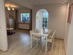 a dining room with a white table and chairs at Waldnähe & Altstadtflair Souterrain mit Terrasse in Rinteln