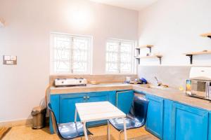 a kitchen with blue cabinets and a white table at Village Sunset Paradise Beach Resort in Morjim