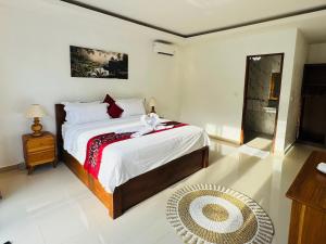 a bedroom with a large bed and a mirror at Villa in Ubud