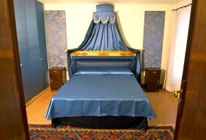 - une chambre avec un lit bleu à baldaquin bleu dans l'établissement Sarai Apartments, à Venise
