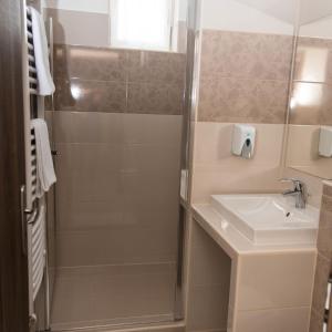 a bathroom with a shower and a sink at Rózsakő Panzió in Kisvárda