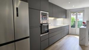 a kitchen with gray cabinets and a refrigerator at Casa Valles Verdes in Reocín