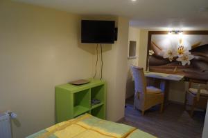 ヴェルニゲローデにあるFeWo Carmenのベッド、デスク、テレビが備わるホテルルームです。