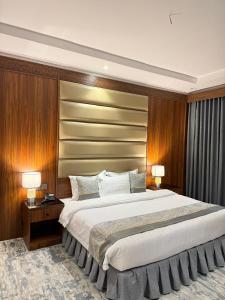 a bedroom with a large bed and two lamps at Hotel Ajnihat Safwat Taiba-فندق أجنحة صفوة طيبة in Al Madinah