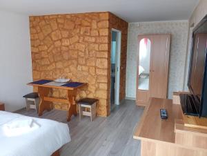 a hotel room with a bed and a stone wall at Casa Tamara in Turda