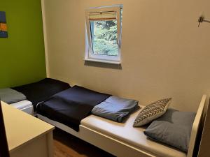 a small room with two beds and a window at Ferienwohnung Magdalena in Hohnstein