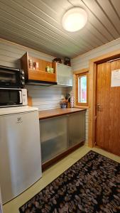 a kitchen with a white refrigerator and a microwave at Sandholm Cottage in Nötö