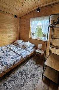 a bedroom with a bed and a ladder and a window at Domki u Ewci - Domki całoroczne in Uherce Mineralne