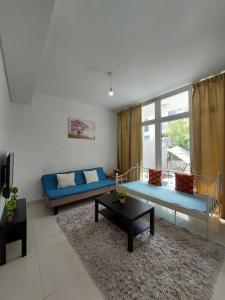 a living room with blue couches and a large window at Damac Hills 2- 3BR Townhouse - Homeyvillas in Dubai