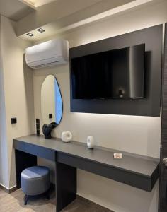 a room with a desk with a tv on the wall at sarti luxury diaMoNd in Sarti